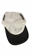 Load image into Gallery viewer, Black and white cap on a textured surface