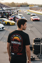 Load image into Gallery viewer, Man wearing a black t-shirt with racing graphics at a race track.